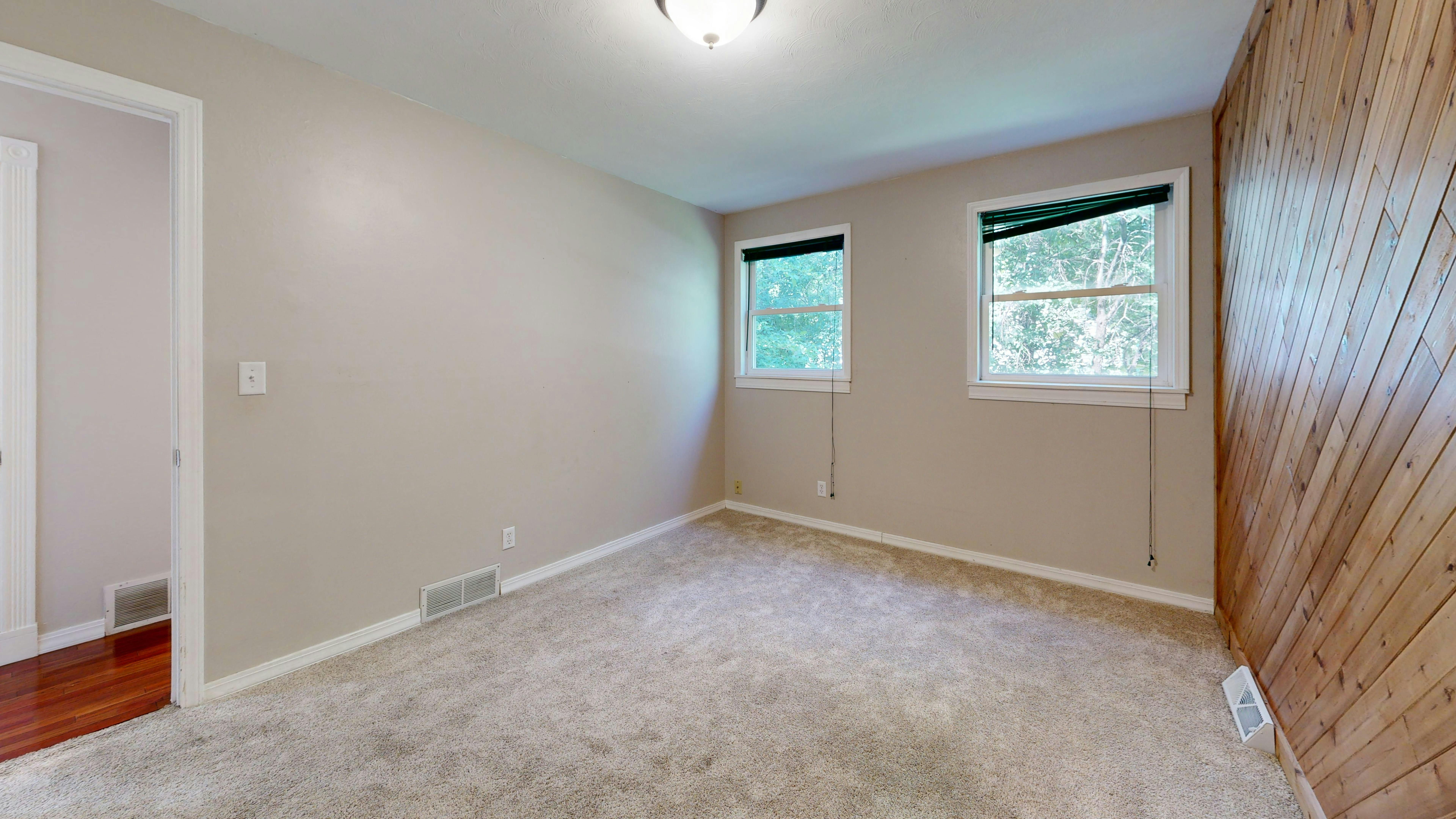 Carpet installation in bedroom with hardwood hallway