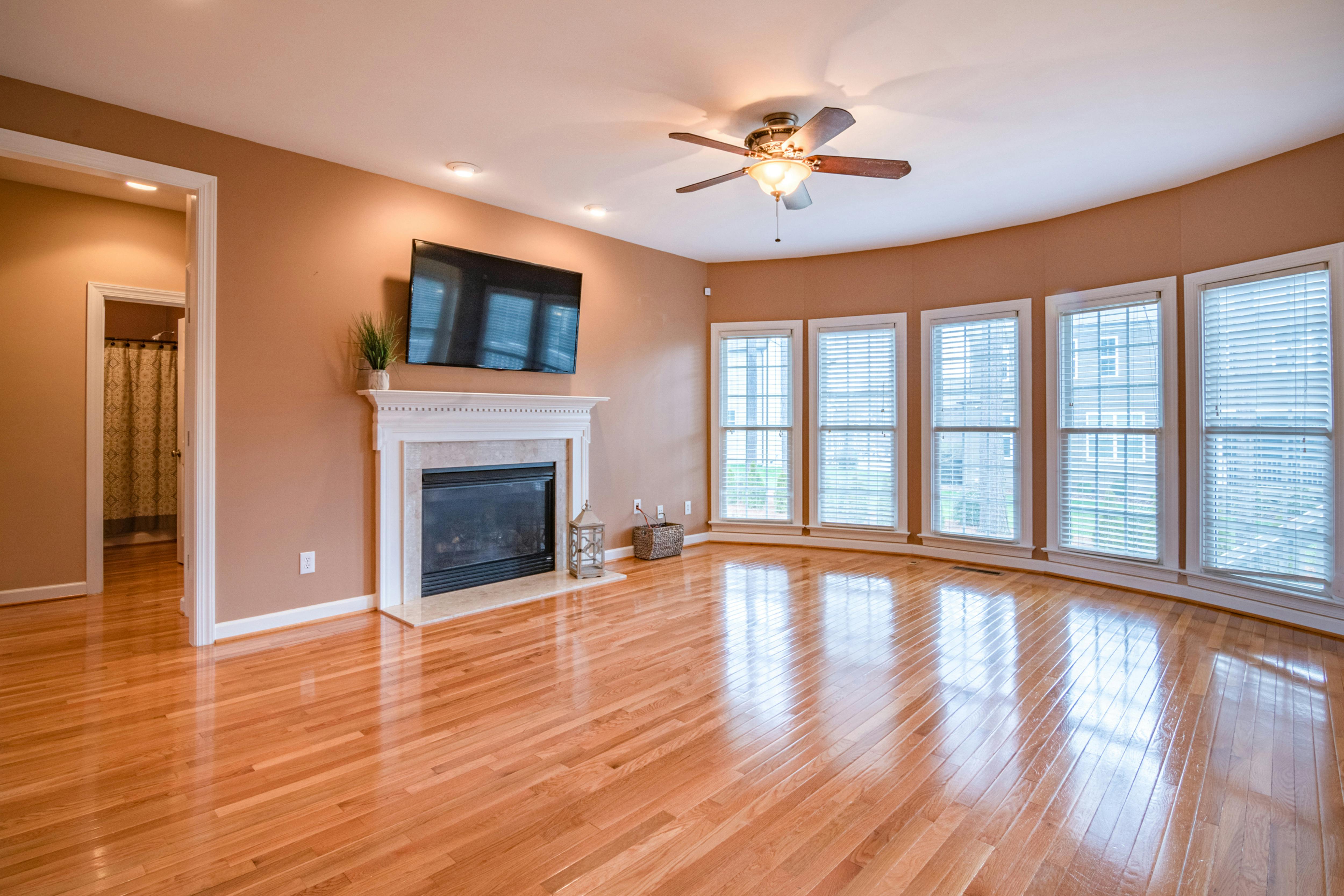 Light natural hardwood flooring with wainscoting and arched window